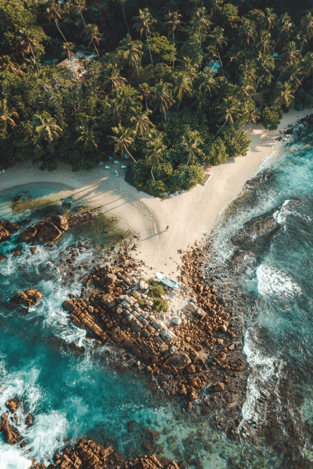 Secluded beach with lush tropical trees and rocky shoreline, perfect for relaxing getaways.