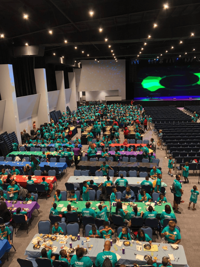 Huge conference with many attendees and colorful tables at QuestForDirections event.