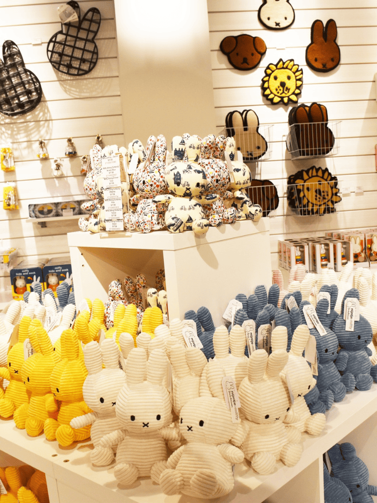 Playful stuffed bunny toys in pastel colors on store display, cute plush animal gifts for children, adorable soft toys for kids.