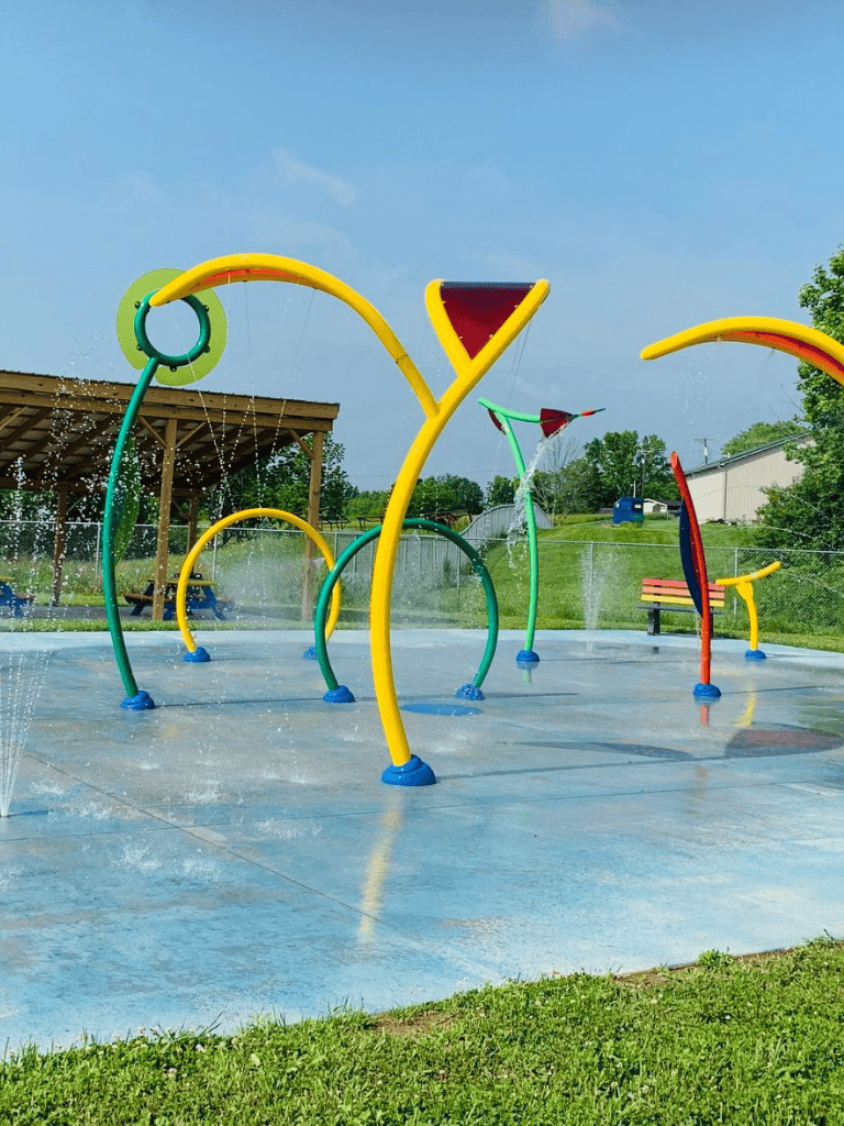 Colorful splash pad water play area with vibrant spraying fountains for kids' fun.