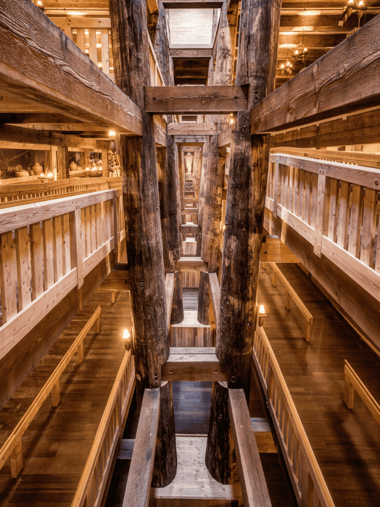 Intricate wooden beams and rustic architecture inside a traditional mill or barn.