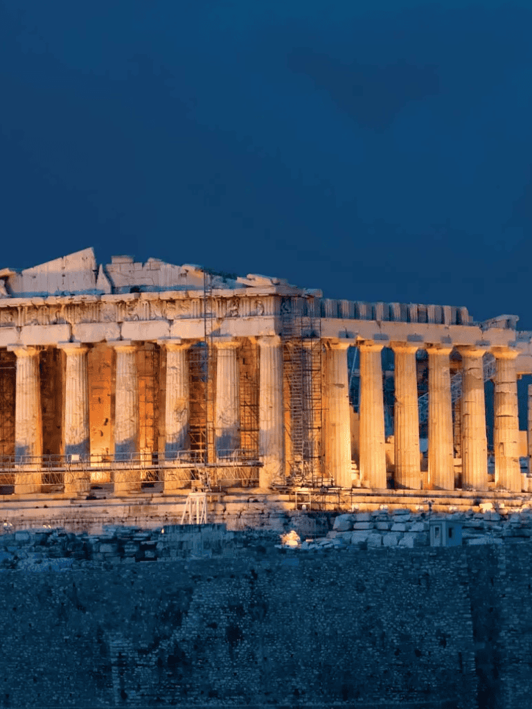 Ancient Greek Parthenon temple illuminated at dusk, showcasing historical architecture.