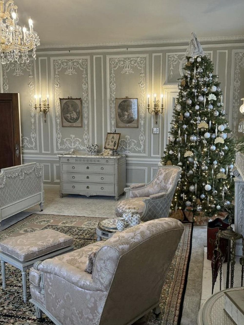 Elegant Christmas living room with decorated tree and vintage furniture.