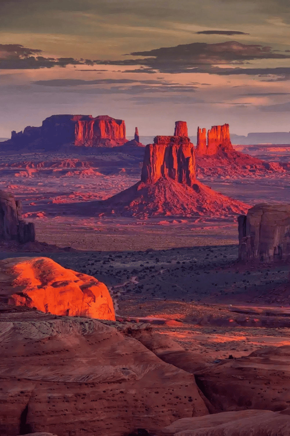 Vibrant photograph of Monument Valley at sunset, showcasing iconic rock formations and desert landscape.