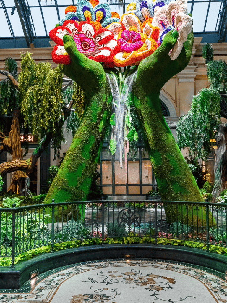 Vibrant floral topiary with cascading water display at QuestForDirections indoor garden.