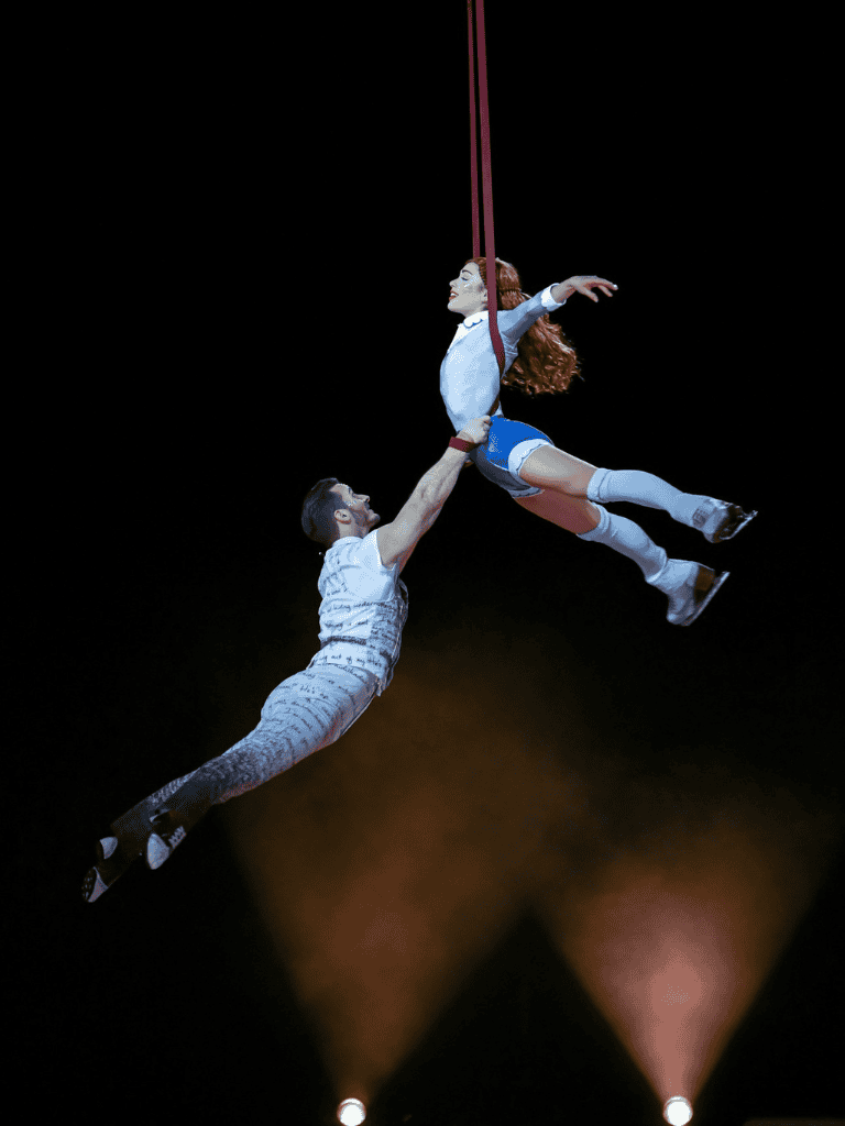 Dynamic aerial circus performance with acrobats on stage at QuestForDirections event.