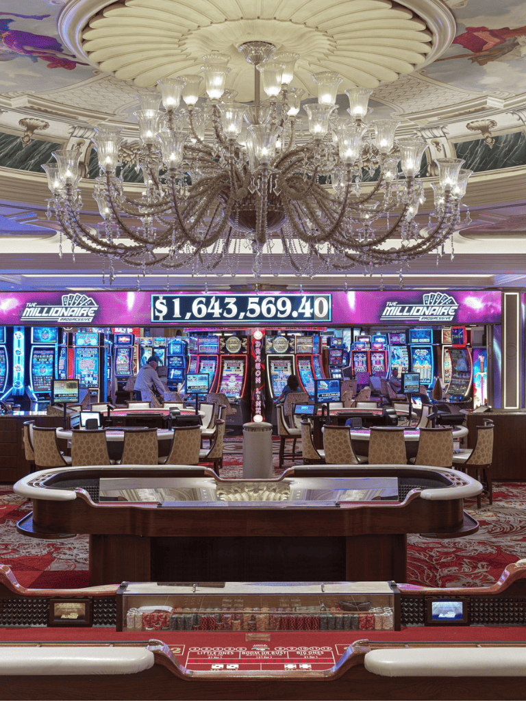 $1,643,569.40 displayed at QuestForDirections casino, featuring slot machines and luxurious chandeliers.