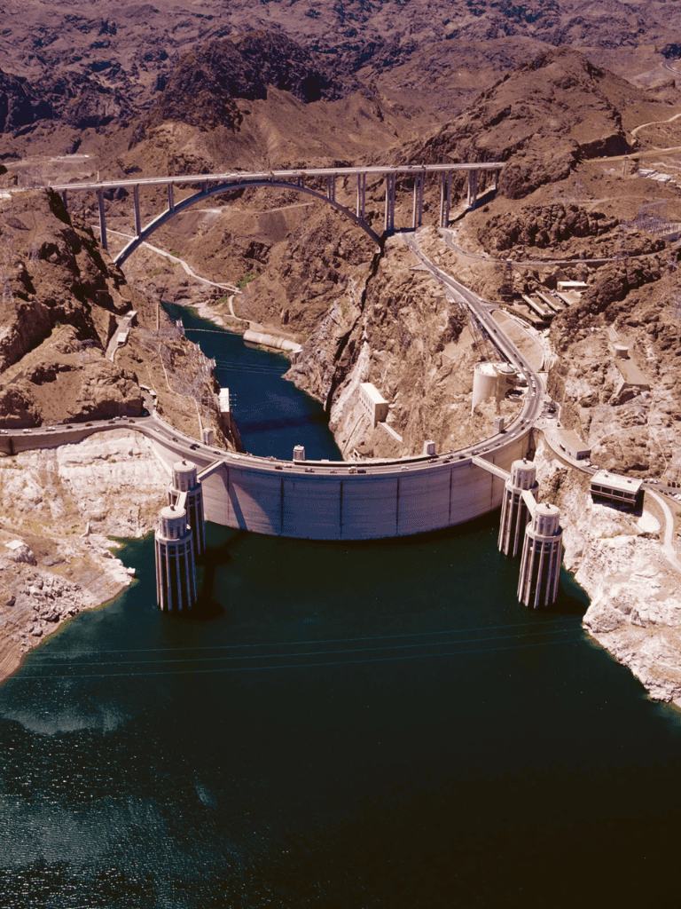 Dam irrigation reservoir with mountain scenery and bridges, water management infrastructure, authentic desert landscape.