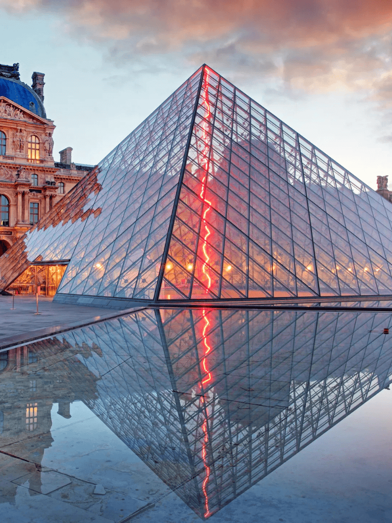 Contemporary glass pyramid at sunset, symbolizing modern architecture and navigation.