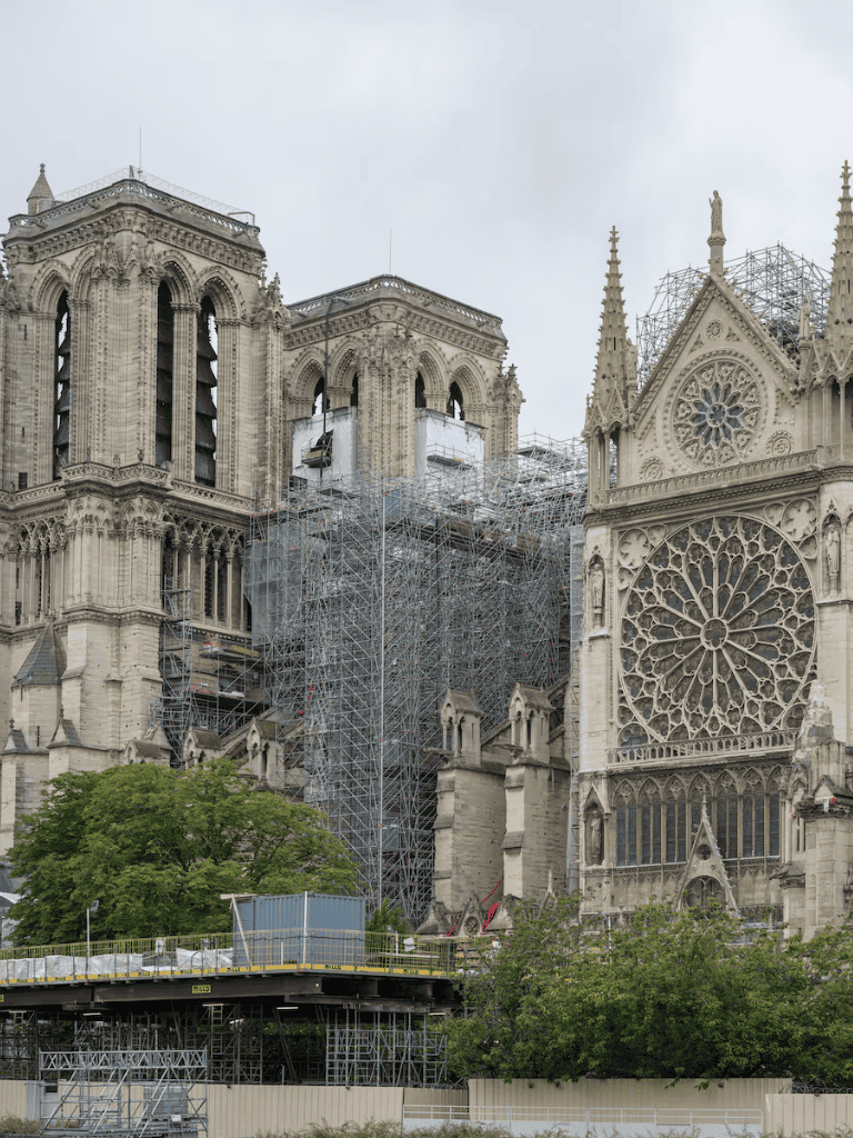 Restoration work on Notre Dame Cathedral in Paris with scaffolding and protective coverings.