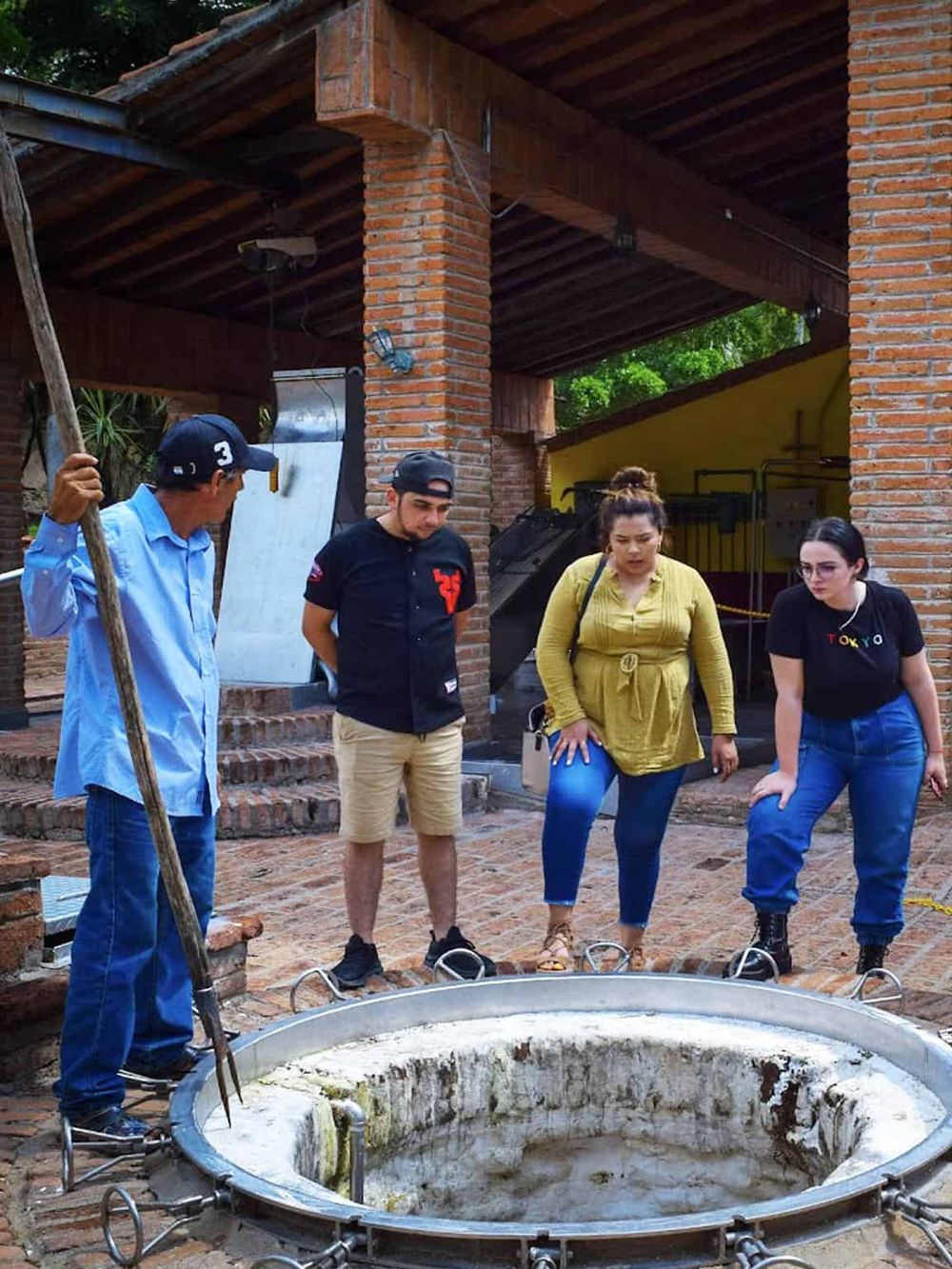 Old well in a historic setting with a group of diverse people exploring on a guided tour.