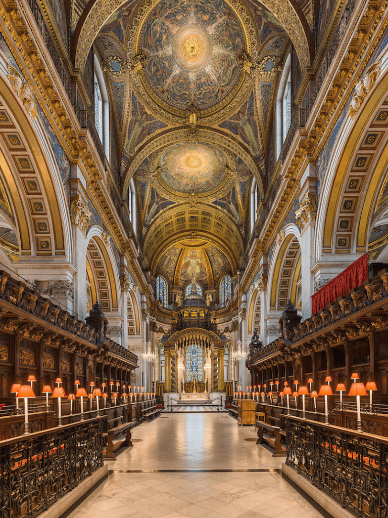 Ornate church interior with gold accents and stunning ceiling artwork, showcasing historic architecture and divine elegance.
