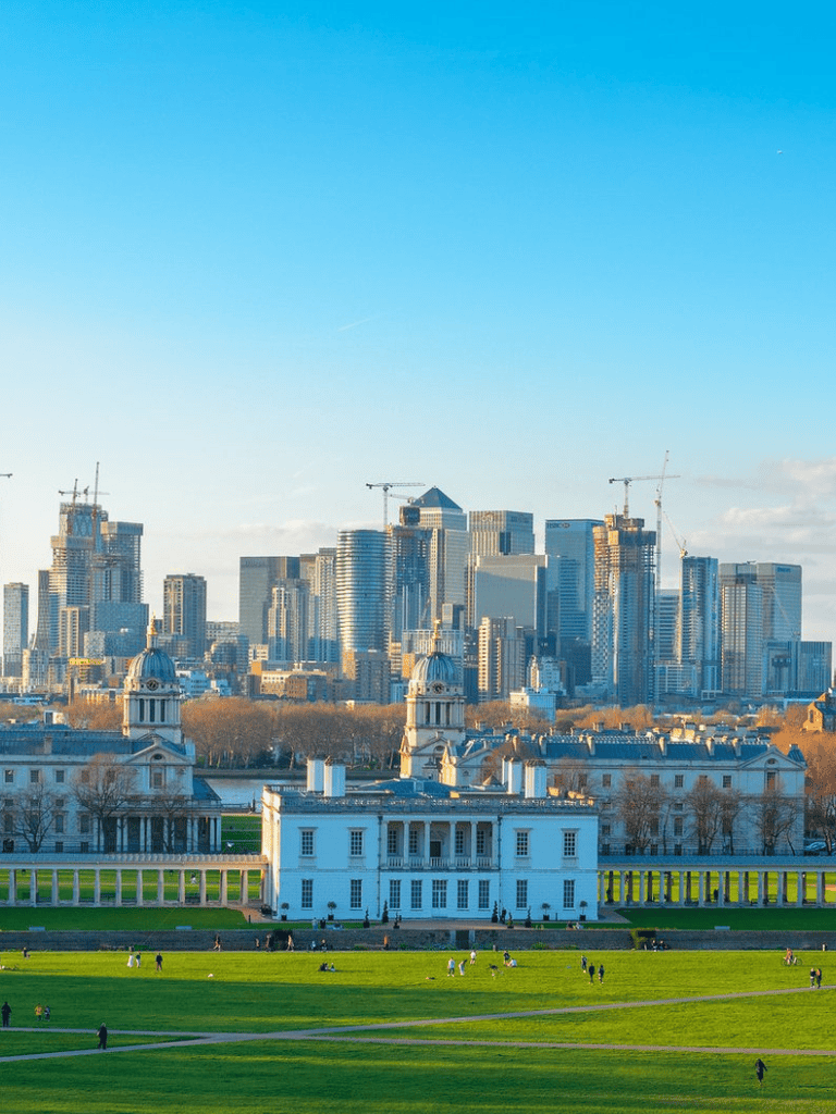 Modern city skyline with historic mansion and green park in foreground, London travel guide destination.
