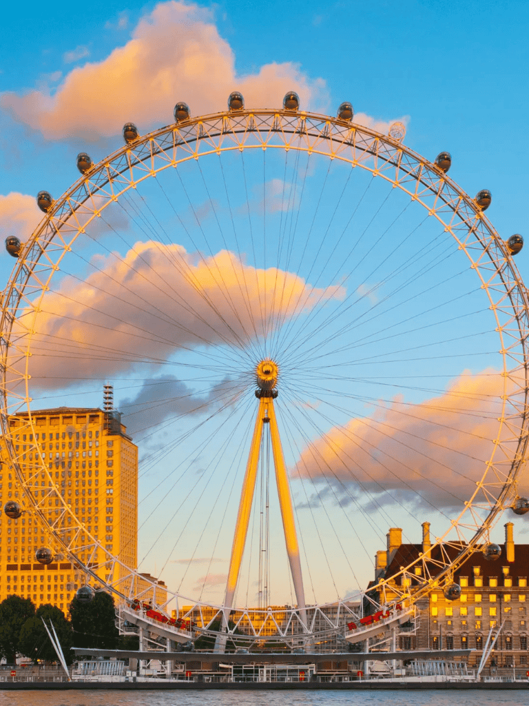 1. Iconic London Eye Ferris wheel at sunset with city skyline in background.