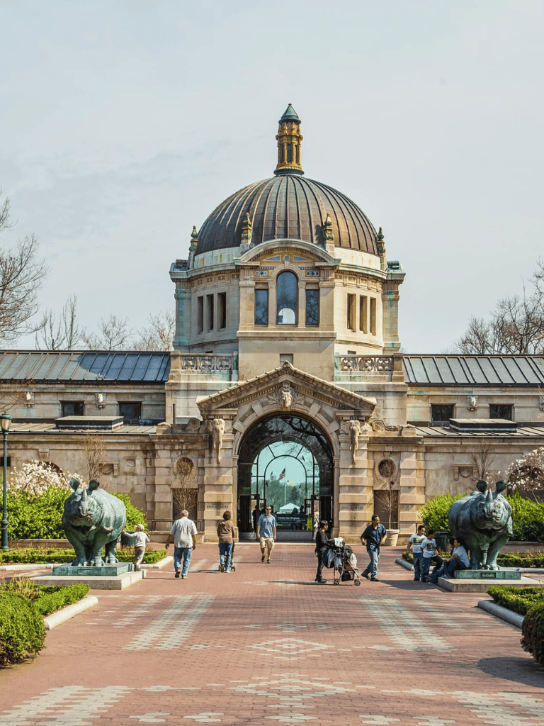 Historic capitol building with domed roof and people enjoying the outdoors.