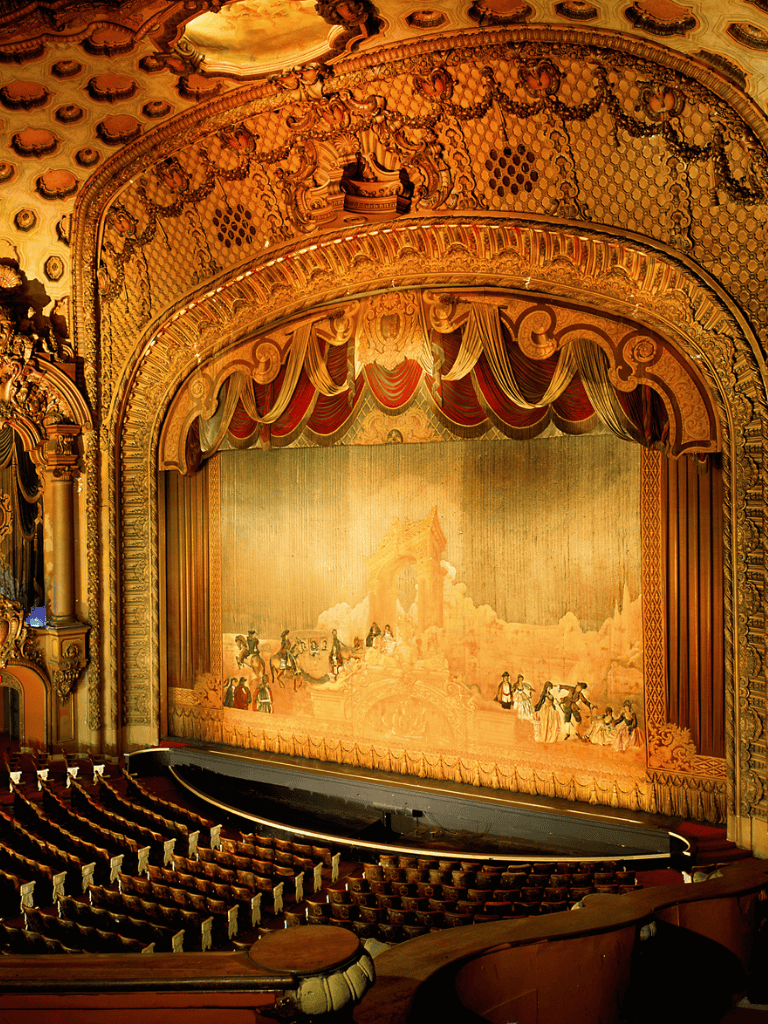Ornate theater with golden detailing and vintage stage, perfect for cultural performances and events.