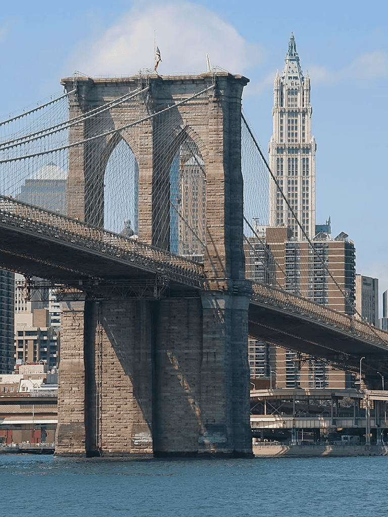 Historic Brooklyn Bridge suspension bridge New York City skyline tall building architecture.