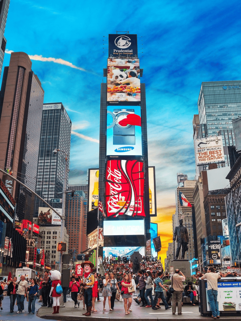 Busy Times Square with digital billboards and tourists in New York City.