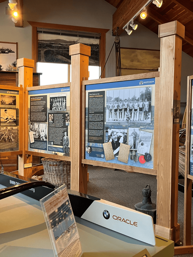 Historical museum exhibits about Dun Hume and world athletics, displayed on wooden boards in a cozy gallery setting.