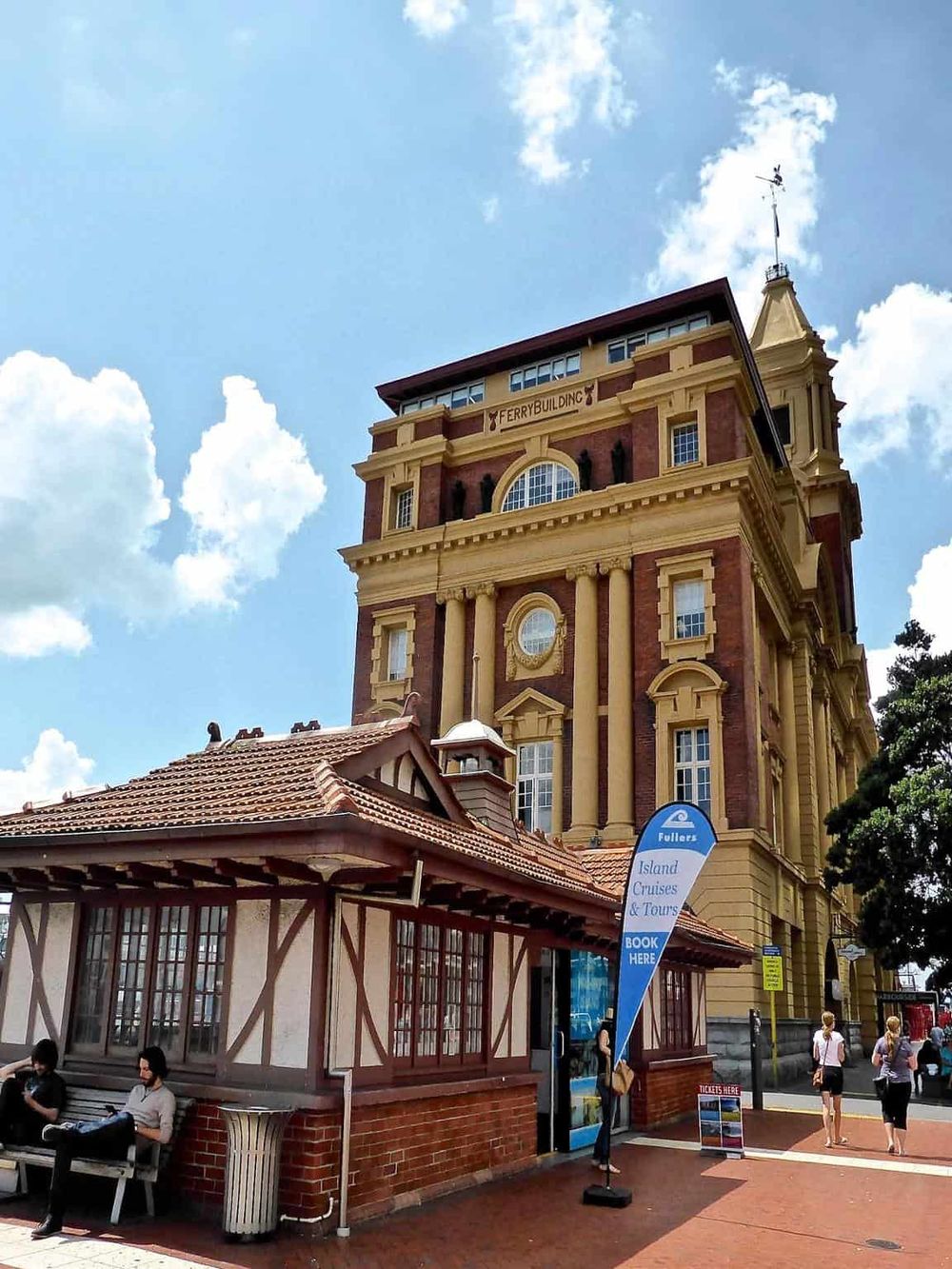 Victorian-style ferry building at Darling Harbour, Sydney, Australia, with tour signage and visitors.