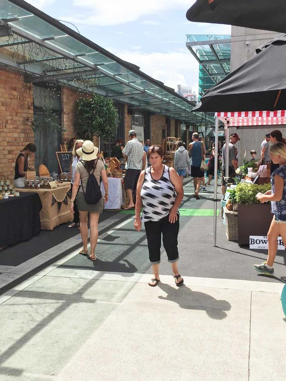 Vibrant outdoor market with diverse vendors and shoppers, showcasing local crafts and organic products.