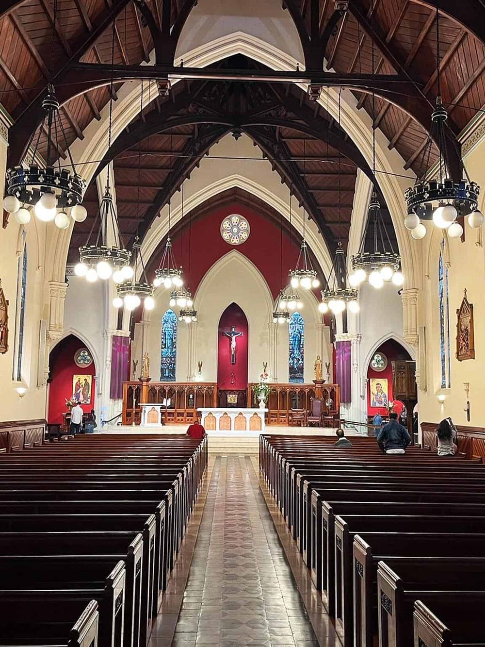 Intricate church interior with wooden pews, stained glass windows, and religious statues for spiritual guidance.