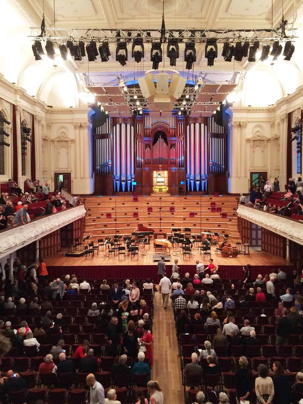 Elegant concert hall interior with stage, pipe organ, and audience, perfect for classical music performances.