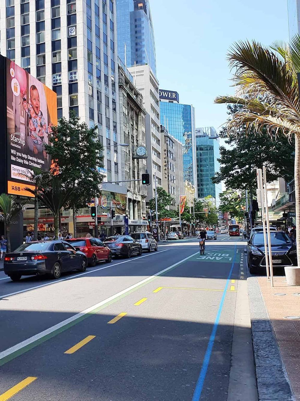 Bright city street with high-rise buildings, bike lane, and active traffic, perfect for urban navigation.