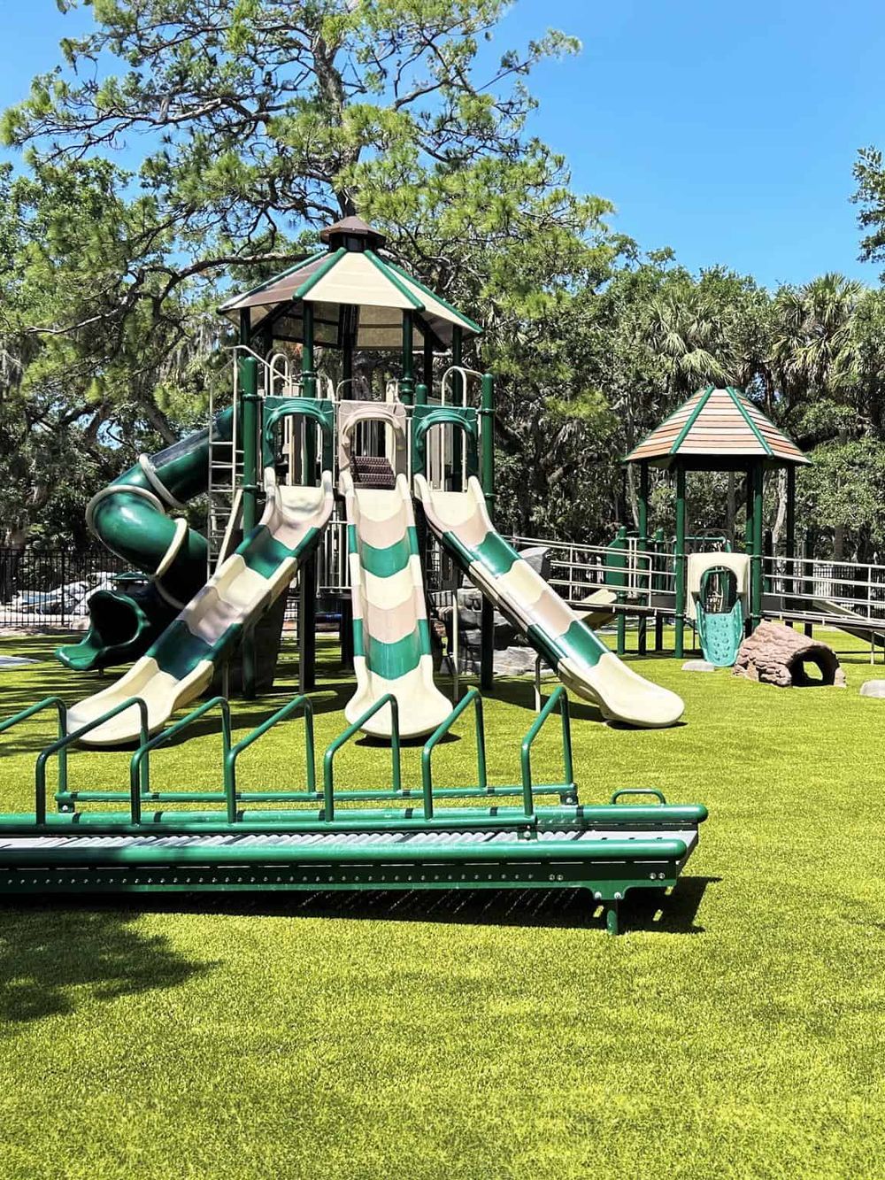 Colorful playground slide structure in a lush green park, ideal for children's outdoor activities and family fun.