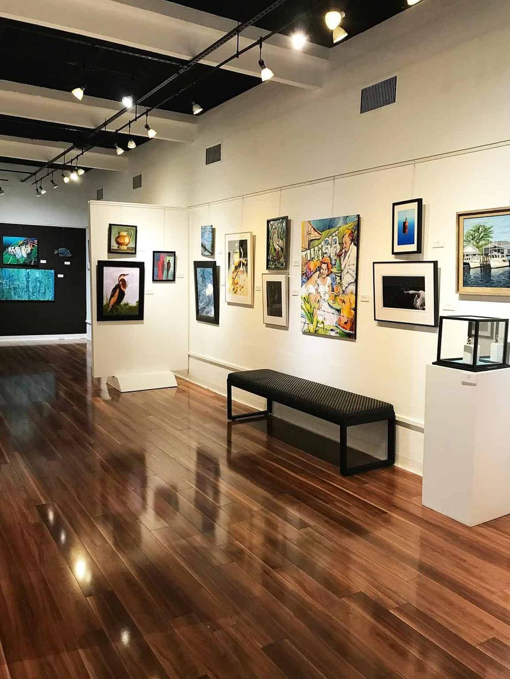 Modern art gallery showcasing diverse artwork and paintings in a bright, contemporary setting.