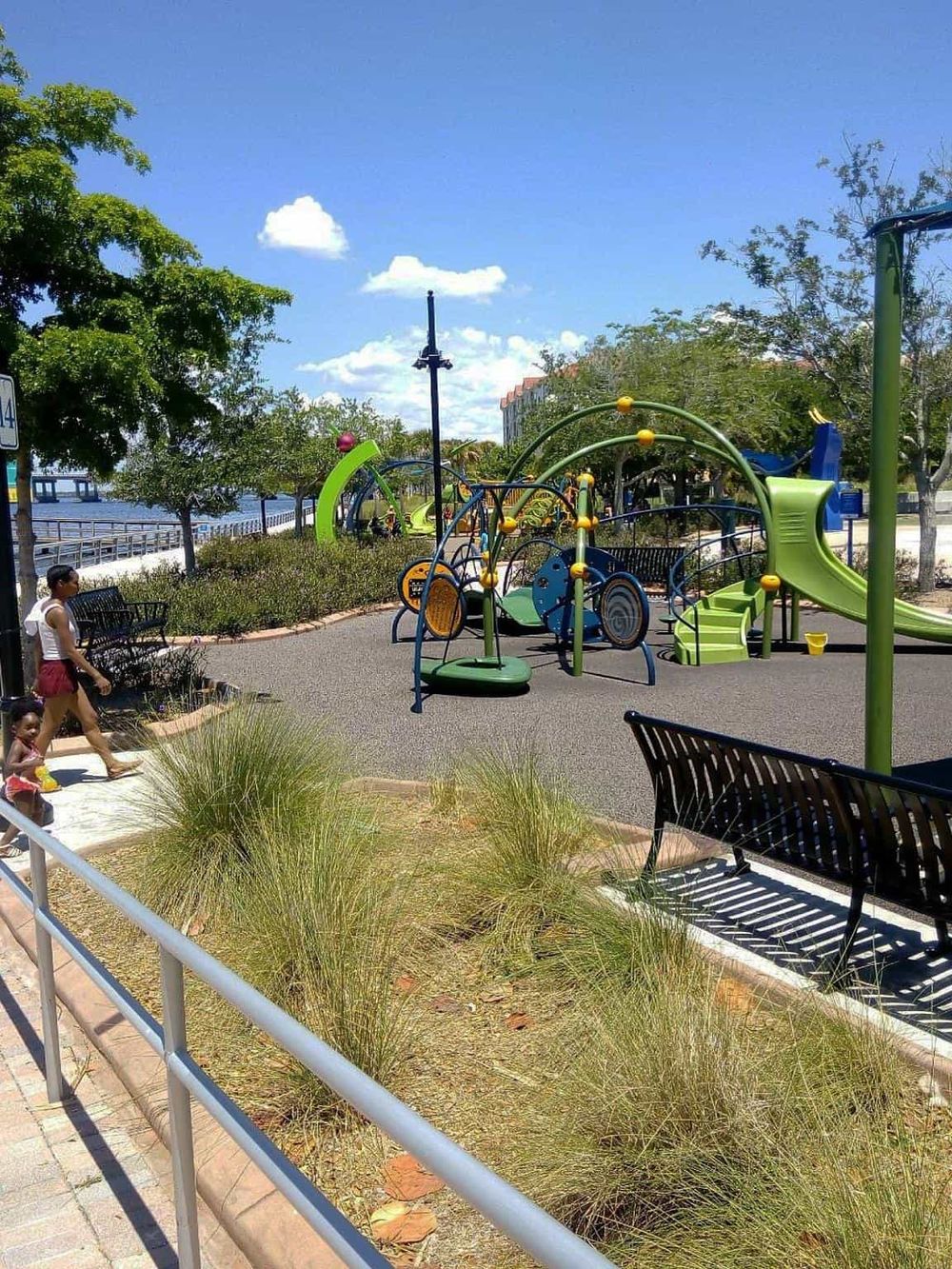 Colorful outdoor playground equipment at scenic park near water, perfect for family fun and recreation.