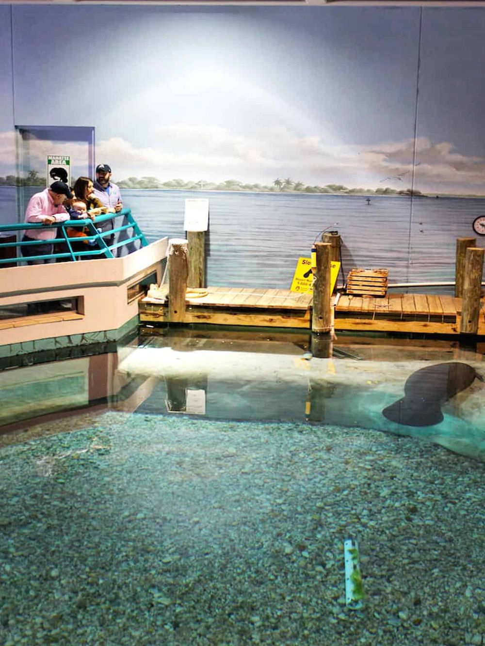 Indoor water-themed attraction at QuestForDirections, family enjoying the immersive lake mural.