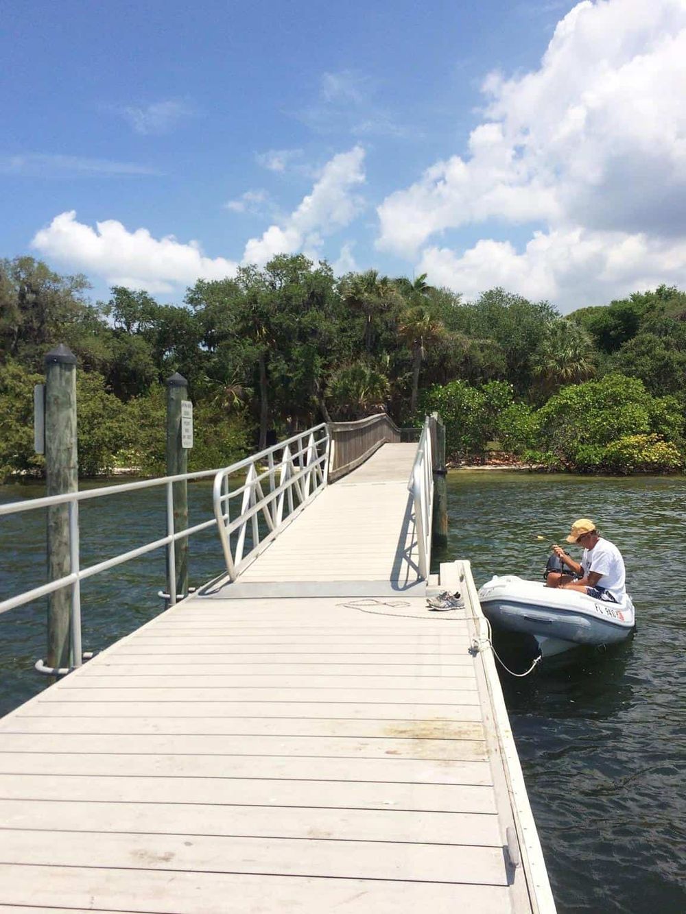 Dock extending over water with lush greenery in background, perfect for scenic boat rides and nature exploration.