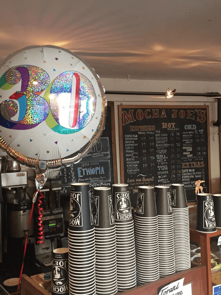 Colorful 30th birthday balloon at Mocha Joe's coffee shop celebrating milestone.