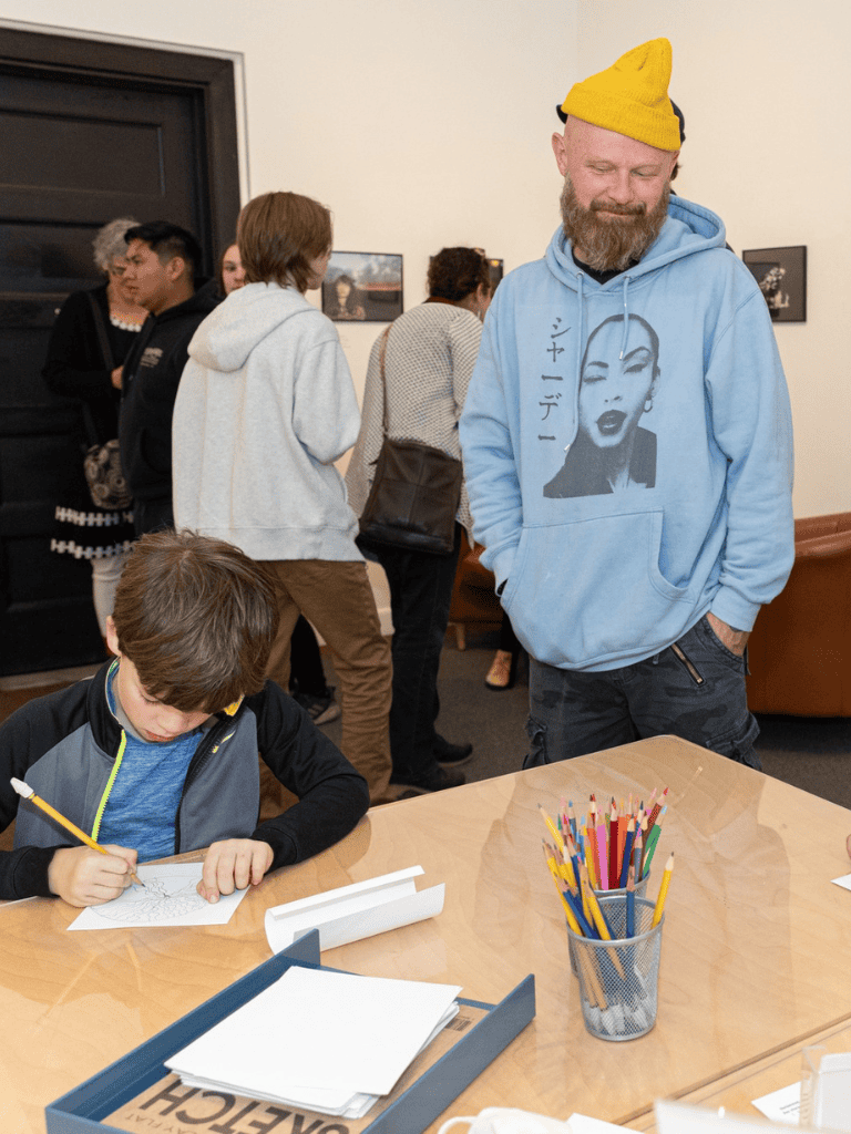 Colorful community art event at QuestForDirections, kids engaging in creative activities, diverse group, indoor art gallery setting.