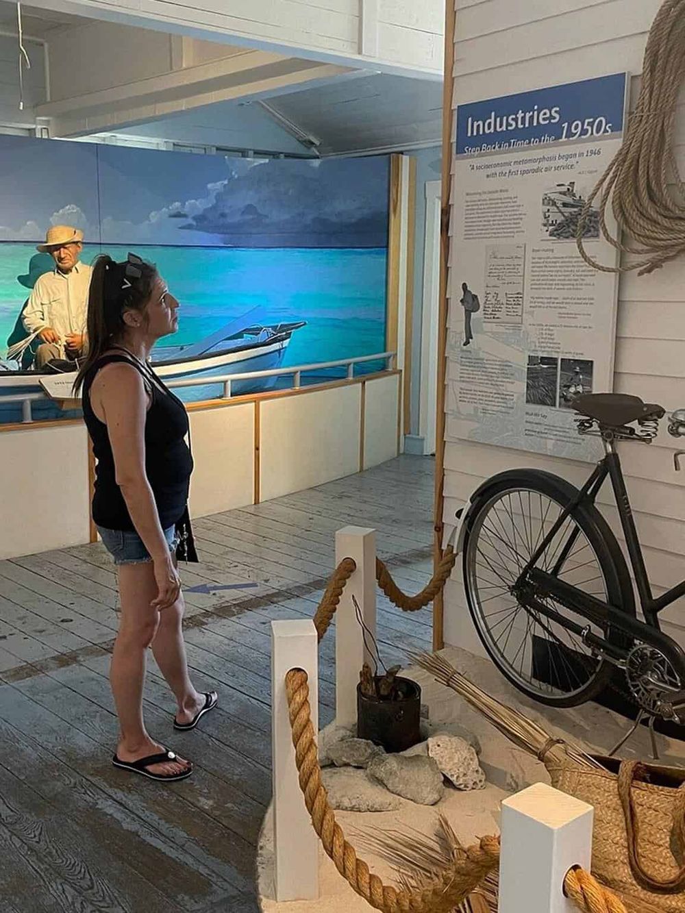Vintage maritime exhibit showcasing nautical history and watercraft, with informational displays and a bicycle for educational purposes.