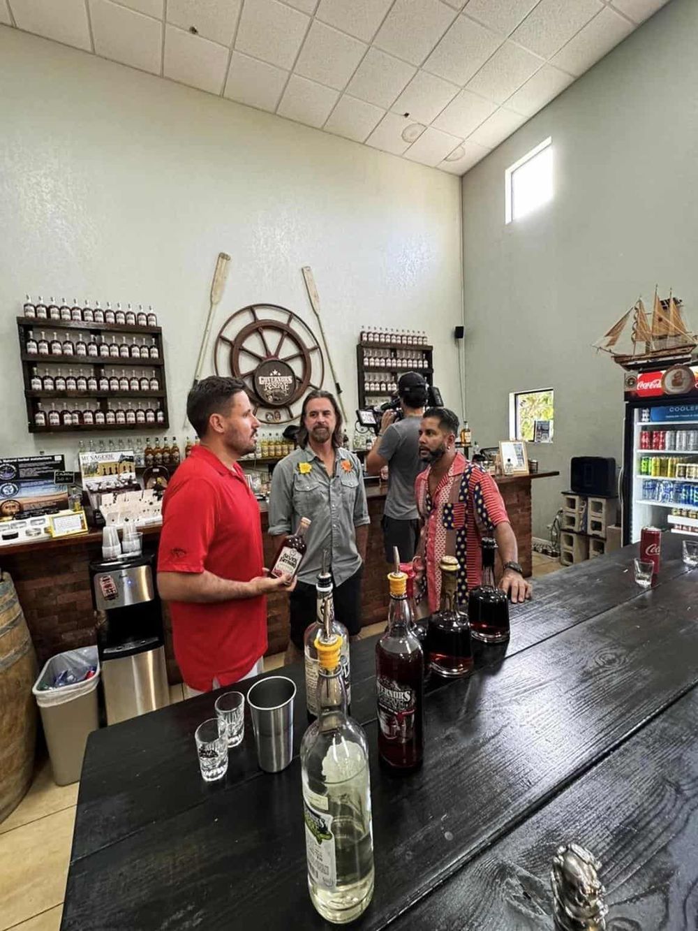 Vape shop interior with staff and customers, shelves with e-liquids and accessories, casual atmosphere for vaping enthusiasts.