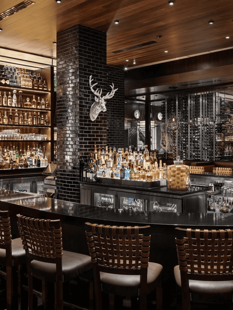 Stylish bar with black brick walls and modern decor for dining and drinks.