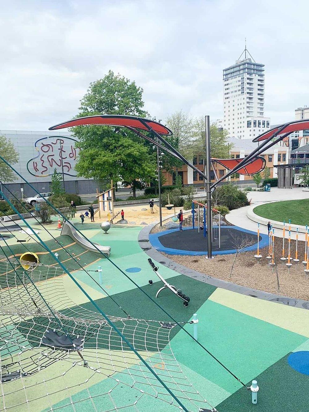 Colorful playground with modern design and city skyline background, perfect for family fun.