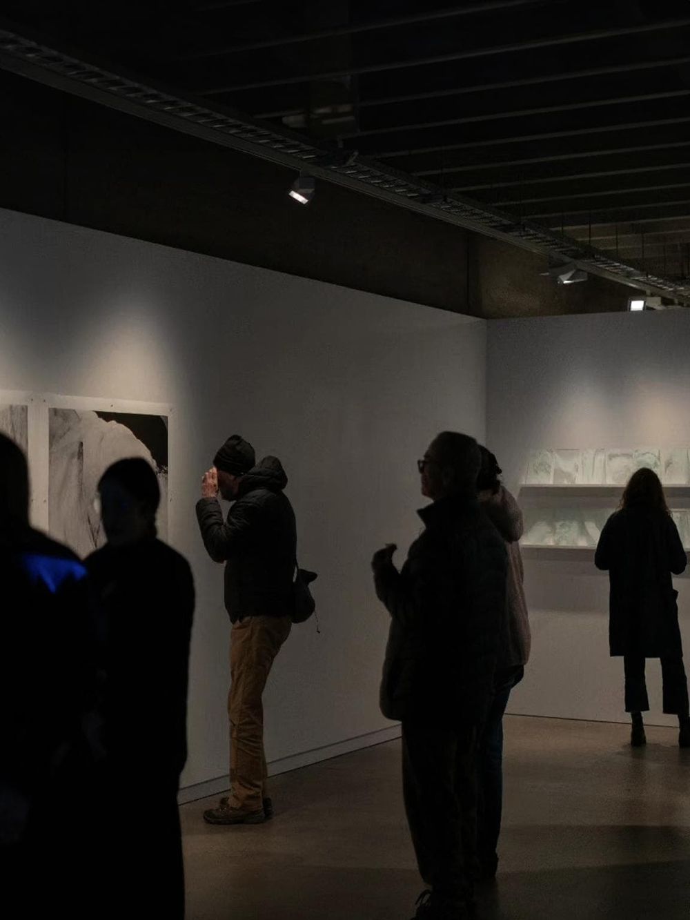 Colorful abstract art displayed in a contemporary art gallery with visitors observing and appreciating the artwork.