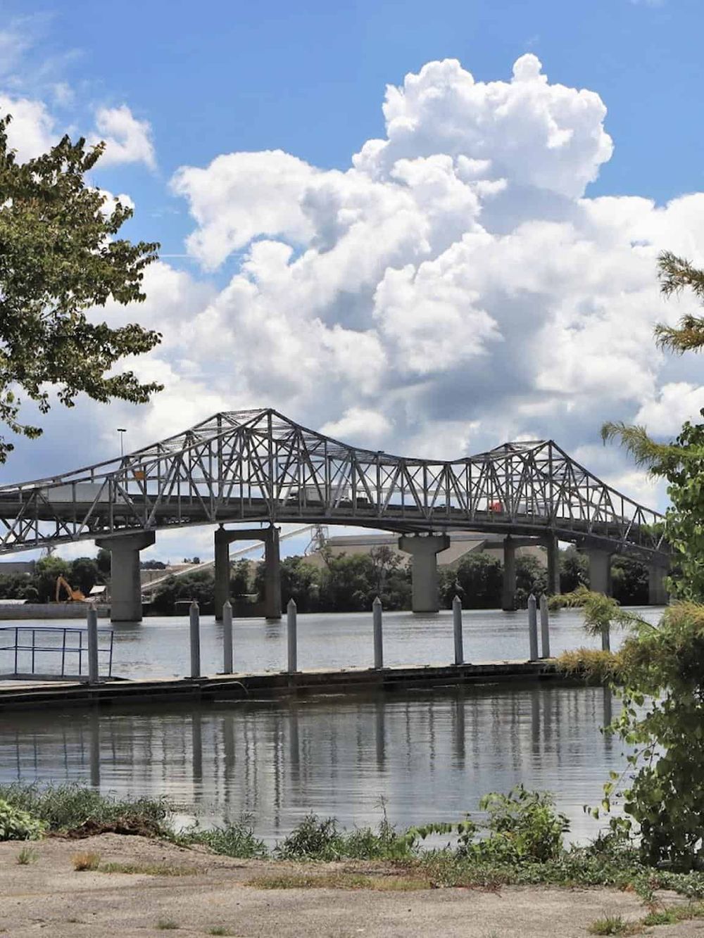 Bridge over water with blue sky and clouds, connecting directions on QuestForDirections site.