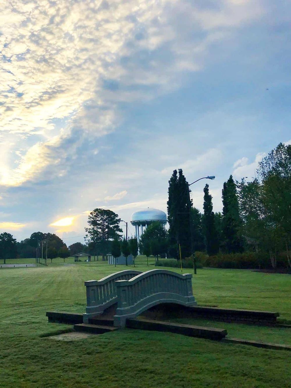 Aerial water tower with a bridge in a park during sunset, showcasing scenic outdoor location and peaceful environment.