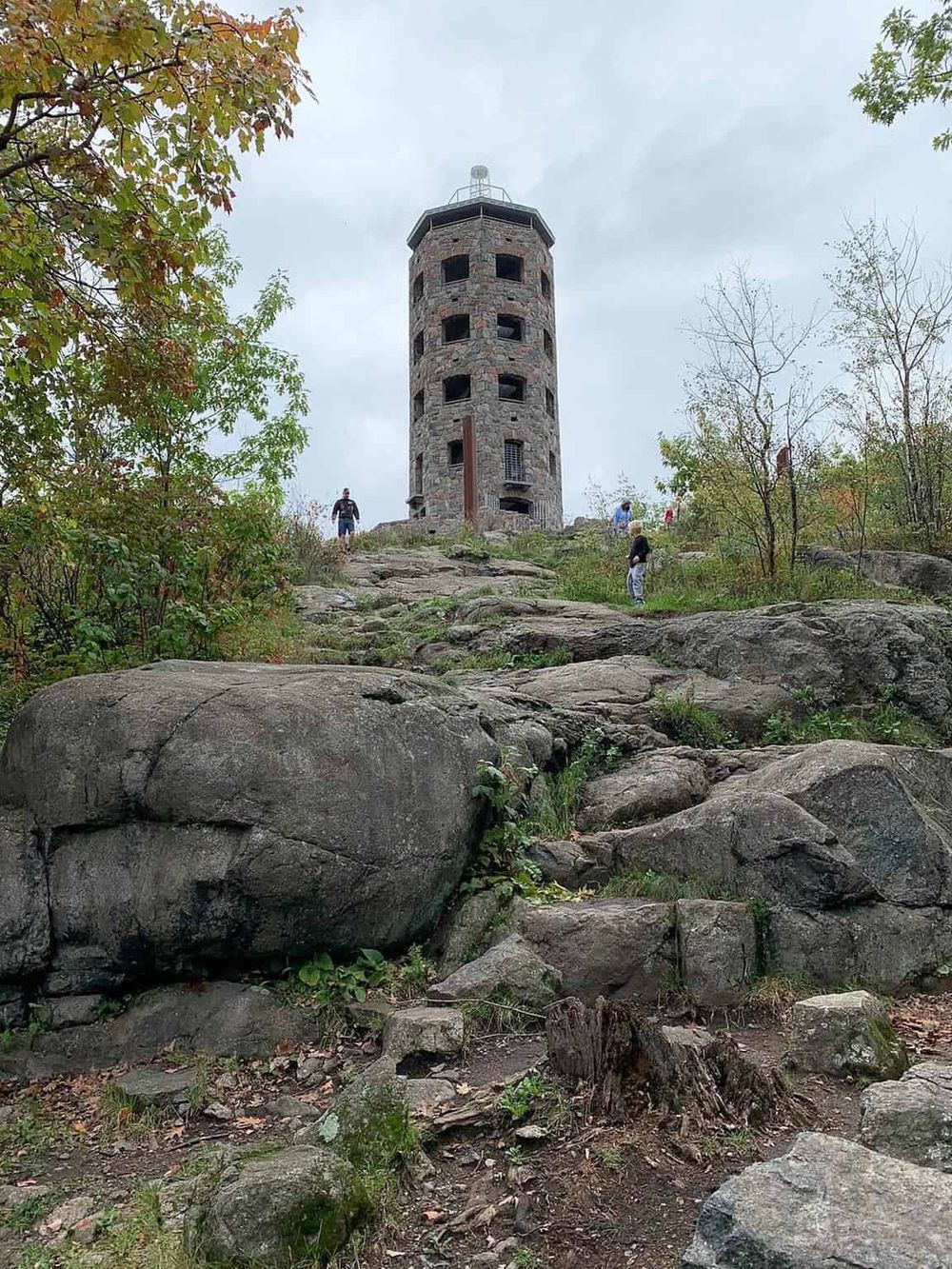 Historic stone fire tower in scenic outdoor setting, popular for hiking and sightseeing.