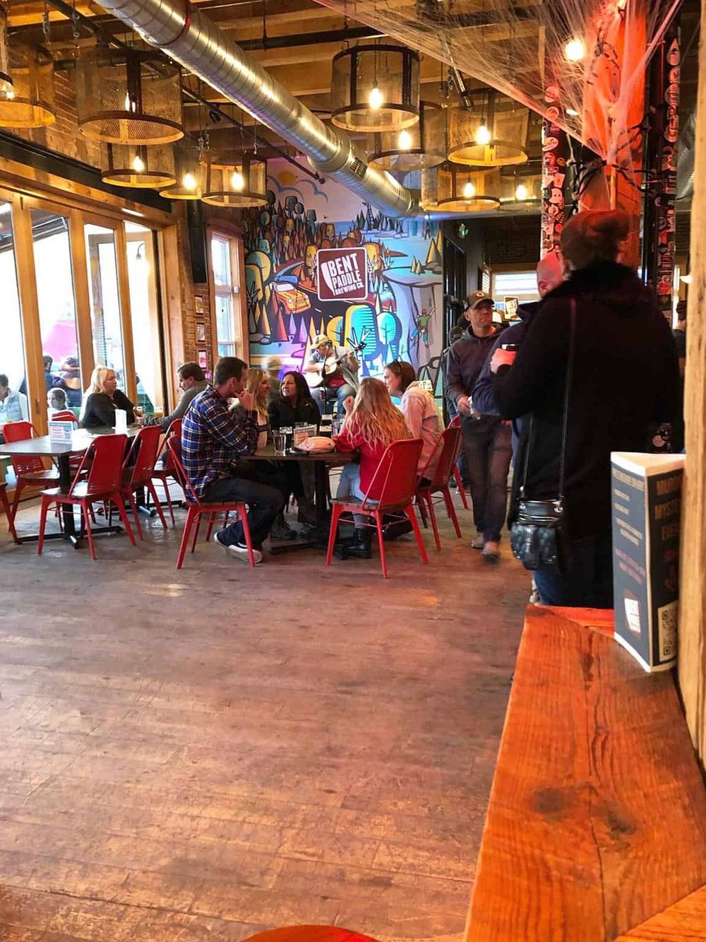 Vibrant indoor dining space at Bent Paddle Brewing Co with colorful artwork and social atmosphere.