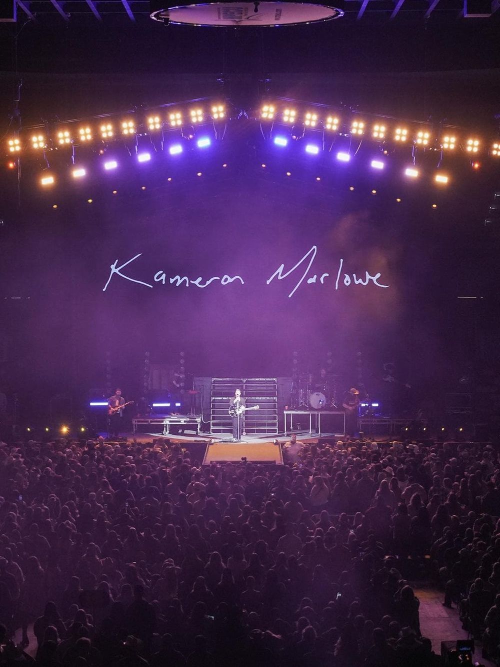 Live concert performance of musician Kamea Marroue on stage with vibrant lighting, capturing dynamic entertainment moments.