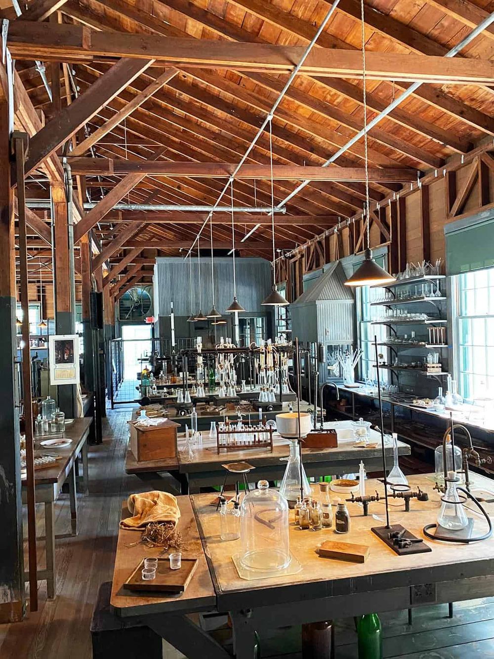 Bright rustic laboratory with wooden beams and scientific glassware for chemistry experiments.