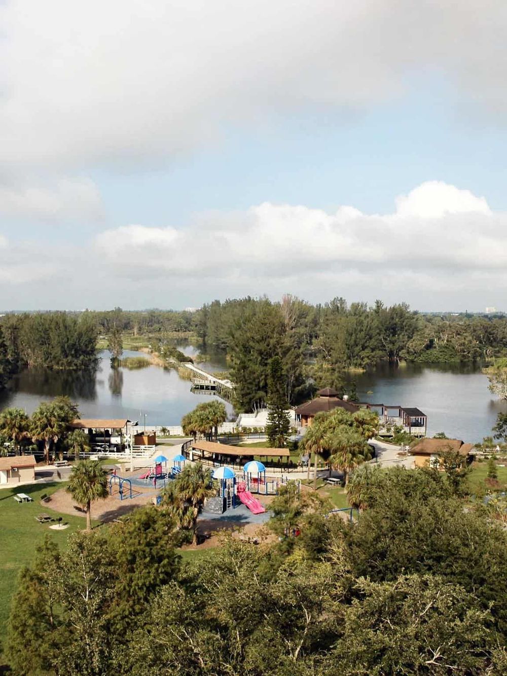 Serene lakeside park with playground, walking trails, and lush greenery, perfect for family outings and outdoor activities.