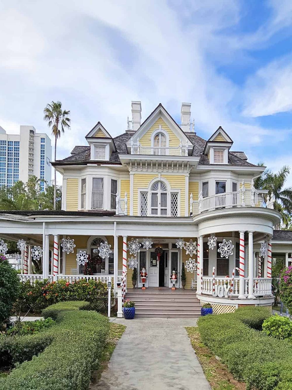 Victorian-style house decorated for Christmas with snowflake ornaments and festive porch displays, showcasing holiday home decor.