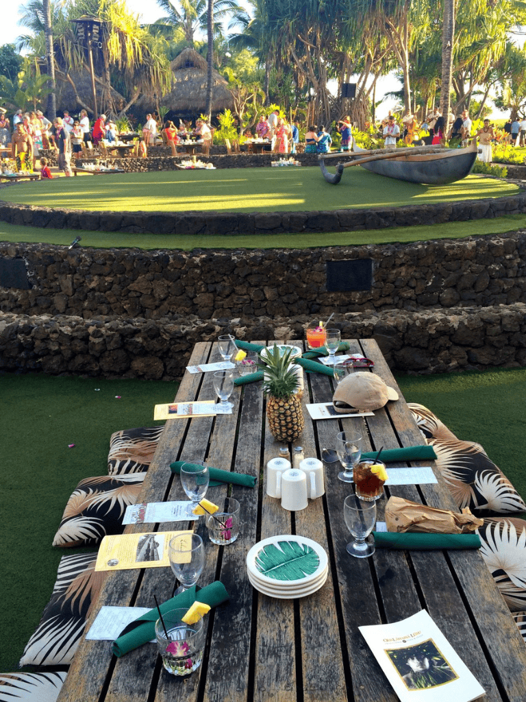 Colorful outdoor event setup with tropical theme, tiki statues, and lush greenery at Quest For Directions.