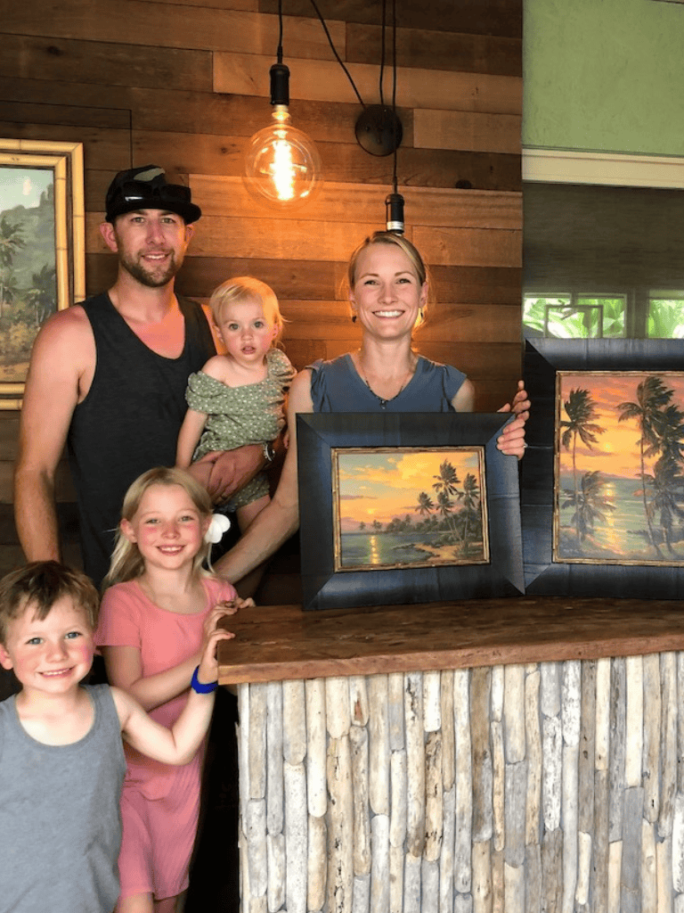 Colorful family portrait with tropical sunset paintings at QuestForDirections art gallery, highlighting island landscapes.